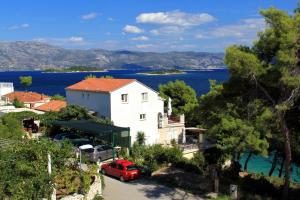 a house with a red car parked in front of it at Apartments by the sea Lumbarda, Korcula - 9260 in Lumbarda
