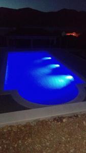 una piscina de agua azul por la noche en Seaside apartments with a swimming pool Kneza, Korcula - 9269, en Račišće