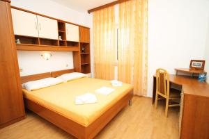 a bedroom with a bed and a desk and a desk at Apartments by the sea Lumbarda, Korcula - 9300 in Lumbarda