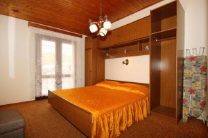 ein Schlafzimmer mit einem Bett mit einer orangefarbenen Tagesdecke in der Unterkunft Apartments by the sea Brna, Korcula - 9187 in Brna