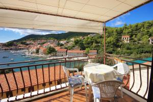 einen Balkon mit einem Tisch und Stühlen sowie Blick auf das Wasser in der Unterkunft Apartments by the sea Brna, Korcula - 9187 in Brna