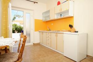 a kitchen with a white refrigerator and a table at Apartments by the sea Lumbarda, Korcula - 9263 in Lumbarda