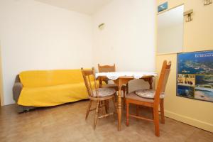 a dining room with a table and chairs and a bed at Apartments by the sea Lumbarda, Korcula - 9263 in Lumbarda