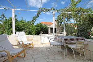 a patio with a table and chairs on a patio at Apartments by the sea Lumbarda, Korcula - 9263 in Lumbarda
