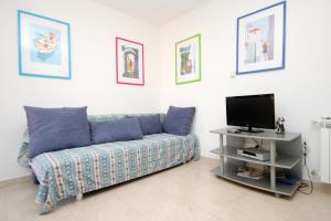 a living room with a couch and a tv at Apartments and rooms by the sea Korcula - 9267 in Korčula