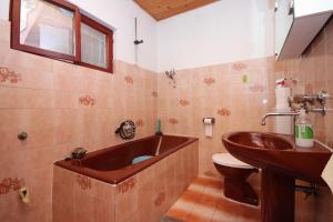 a bathroom with a tub and a toilet and a sink at Seaside secluded apartments Grscica, Korcula - 9228 in Prizba