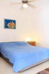 a bedroom with a blue bed and a ceiling fan at Apartments and rooms by the sea Korcula - 9267 in Korčula