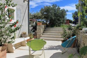two chairs and a staircase in a yard at Apartments and rooms by the sea Korcula - 9267 in Korčula