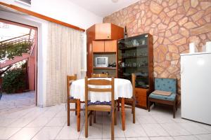 una sala da pranzo con tavolo e frigorifero di Apartments by the sea Brna, Korcula - 9275 a Brna Altre 17 foto