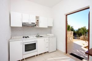 a kitchen with white appliances and a large window at Apartments by the sea Zavalatica, Korcula - 9274 in Zavalatica