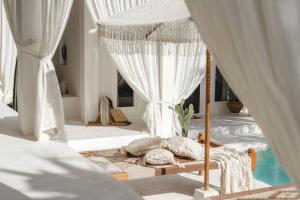 ein Schlafzimmer mit einem Himmelbett und einem Pool in der Unterkunft Villa Ores Bali in Canggu
