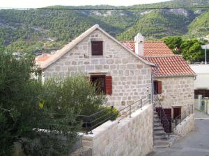 a stone house with a staircase leading up to it at Apartments with a parking space Komiza, Vis - 9247 in Komiža