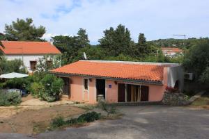 a small house with an orange roof at Apartment Veli Losinj 8029b in Veli Lošinj