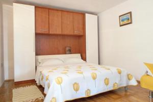 a bedroom with a large white bed with a wooden headboard at Apartment Veli Losinj 8029b in Veli Lošinj