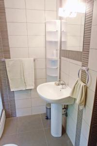 a white bathroom with a sink and a mirror at Apartment Veli Losinj 8029b in Veli Lošinj