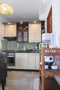 a kitchen with white cabinets and white appliances at Apartment Veli Losinj 8029b in Veli Lošinj