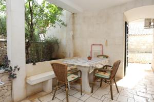 a patio with a table and chairs and a tub at Apartments and rooms by the sea Lumbarda, Korcula - 9305 in Lumbarda