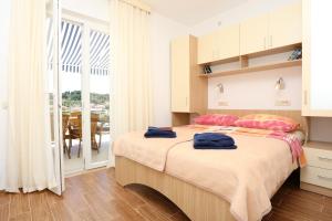una camera da letto con un letto con due asciugamani blu sopra di Apartments and rooms by the sea Lumbarda, Korcula - 9305 a Lumbarda (Lombarda)