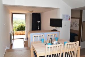 a dining room with a table and a television at Apartments with parking space Cres - 7876 in Cres