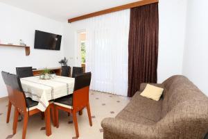 a dining room with a table and chairs and a couch at Apartments by the sea Lumbarda, Korcula - 9304 in Lumbarda