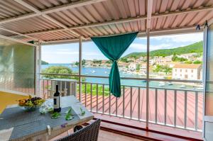 a balcony with a table and a view of the water at Apartments by the sea Brna, Korcula - 9162 in Smokvica