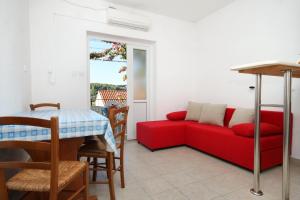 a living room with a red couch and a table at Apartments with parking space Lumbarda, Korcula - 9262 in Lumbarda +17 photos