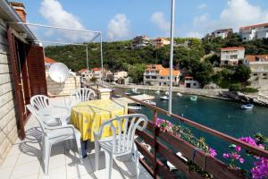 a table and chairs on a balcony with a view of the water at Apartments by the sea Zavalatica, Korcula - 9285 in Zavalatica