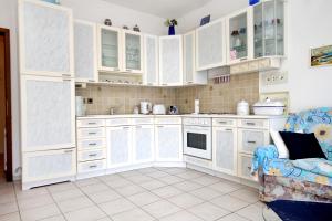 a kitchen with white cabinets and a blue couch at Apartments by the sea Zavalatica, Korcula - 9285 in Zavalatica +27 photos