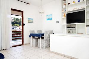 a living room with a table and a tv at Apartments by the sea Zavalatica, Korcula - 9285 in Zavalatica