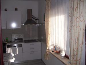 a kitchen with a sink and a window with a curtain at Apartments by the sea Zavalatica, Korcula - 9285 in Zavalatica