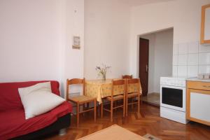 a living room with a couch and a table and chairs at Apartments by the sea Zdrelac, Pasman - 8046 in Ždrelac