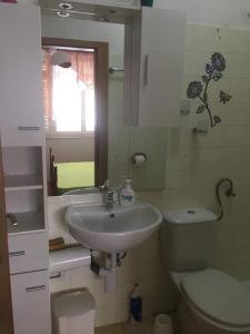 ein Bad mit einem Waschbecken, einem WC und einem Fenster in der Unterkunft Apartments and rooms by the sea Sumartin, Brac - 2953 in Sumartin