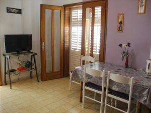 a dining room with a table and a television at Apartments and rooms by the sea Sumartin, Brac - 2953 in Sumartin