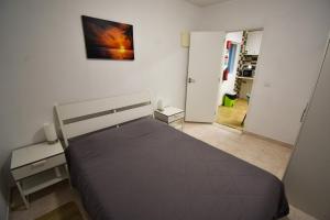 Un dormitorio con una cama y un cuadro en la pared. en Rock’s Beach Spot Front, en Costa da Caparica