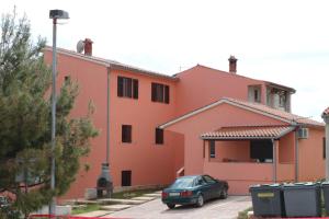 samochód zaparkowany przed czerwonym budynkiem w obiekcie Apartments with a parking space Pula - 7664 w Puli