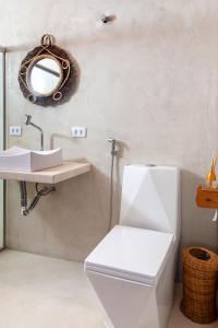 a bathroom with a white toilet and a sink at Mirante Caraiva in Caraíva