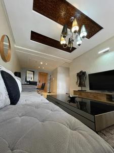 a bedroom with a large bed and a flat screen tv at Luxury apartment in downtown of kenitra in Kenitra