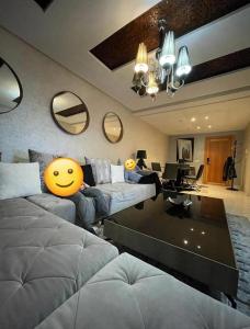 Luxury apartment in downtown of kenitra في القنيطرة: غرفة معيشة مع أريكة عليها وجه مبتسم