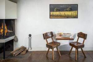 a room with a table and two chairs and a fireplace at Hotel El Remanso Tapalpa in Tapalpa +31 photos