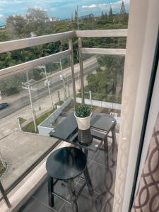 a table and chair on a balcony with a view of a street at GoldenSuites at CoolSuites WindResidences Tagaytay in Tagaytay