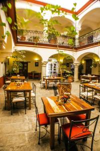 a restaurant with wooden tables and chairs in a room at Parador San Agustin in Oaxaca City
