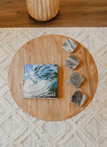 a wooden table with rocks on it with a book at Puamana Maluhia - Two Bedroom / Two Bath Condo in Princeville