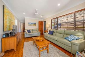 a living room with a couch and a tv at Little Beach Bungalow - at Bartlett's in Bonny Hills