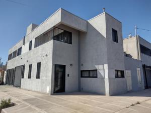 een groot betonnen gebouw met een deur op een parkeerplaats bij Apartamento Agur cerca del Arena Stadium in Maipú