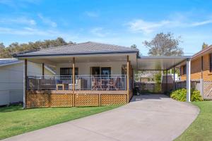 a home with a large porch with a deck at Little Beach Bungalow - at Bartlett's in Bonny Hills