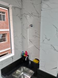 a bathroom with a sink and a shower at Apartamento Pé na Areia - Praia Grande - SP, Aviação in Praia Grande +52 photos