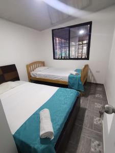 2 camas individuales en una habitación con ventana en Armenia Apartamento, en Armenia
