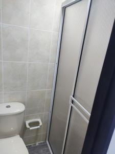 baño con aseo y puerta de ducha de cristal en Armenia Apartamento, en Armenia