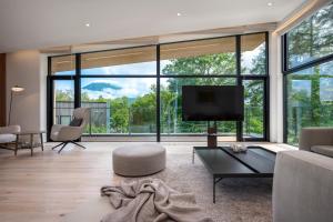 a living room with a tv and a large window at Ryoun by H2 Life in Niseko