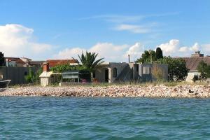 a house on the shore of a body of water at Apartments by the sea Krapanj, Sibenik - 9258 in Brodarica